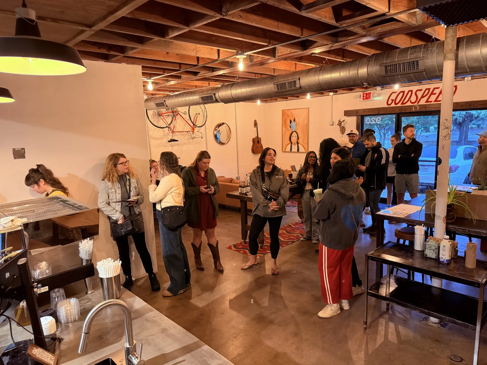 Families and regulars fill Moon Wolf beneath the hand-painted GODSPEED sign.
