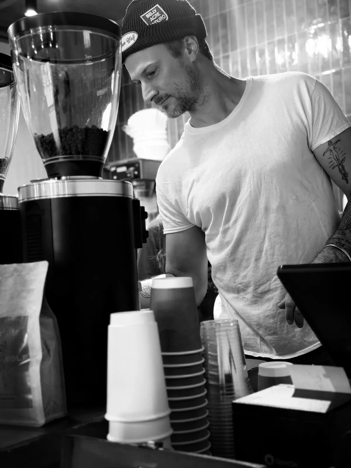 Black-and-white portrait of Richie Conry working behind the Moon Wolf grinder.